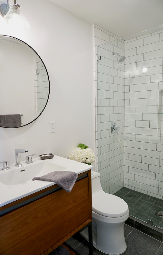 Inspiration for a small midcentury family bathroom in San Francisco with flat-panel cabinets, medium wood cabinets, an alcove shower, a one-piece toilet, white tiles, ceramic tiles, grey walls, slate flooring, a submerged sink, engineered stone worktops, grey floors, a hinged door and white worktops.