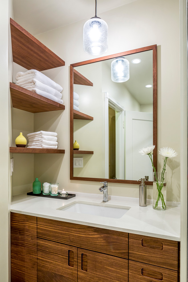 Immagine di una stanza da bagno design con ante lisce, ante in legno bruno, pareti beige e lavabo sottopiano