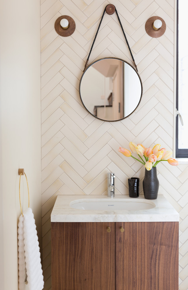 Cette image montre une salle de bain design en bois foncé avec un placard à porte plane, un mur blanc, un plan vasque et un plan de toilette en bois.
