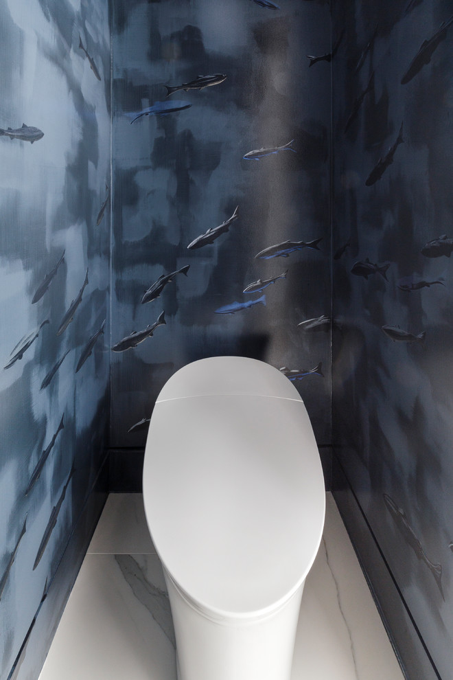 На фото: большой туалет в стиле модернизм с плоскими фасадами, светлыми деревянными фасадами, мраморным полом, врезной раковиной, столешницей из искусственного кварца, серым полом, унитазом-моноблоком и синими стенами