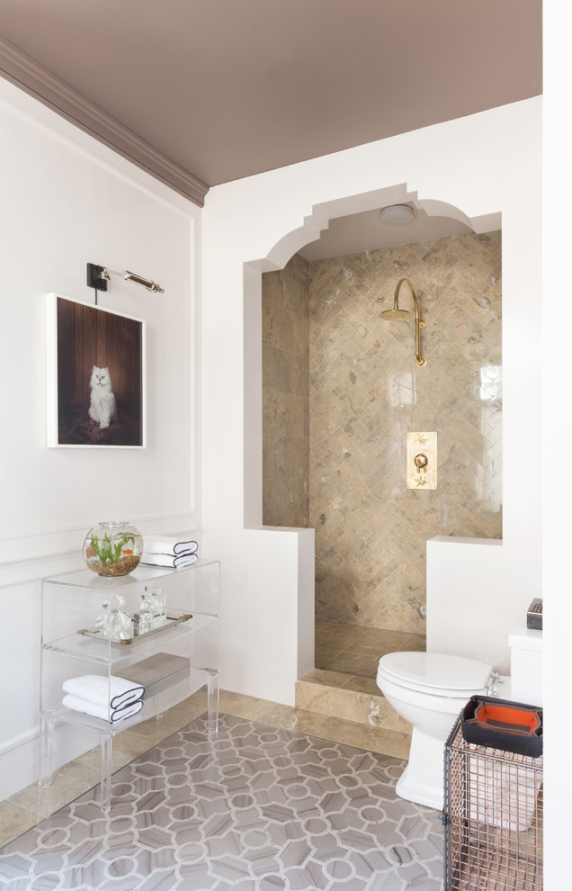 Klassisk inredning av ett badrum, med en öppen dusch, en toalettstol med separat cisternkåpa, beige kakel, vita väggar, marmorgolv, öppna hyllor, med dusch som är öppen och beiget golv