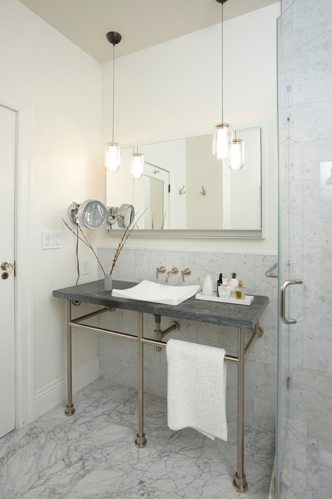 Example of a classic gray tile bathroom design in San Francisco with a console sink and soapstone countertops