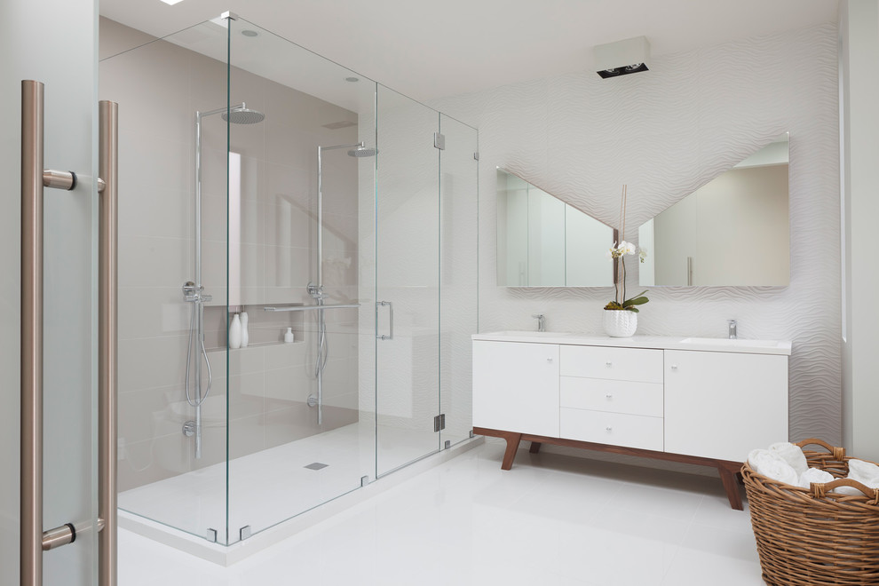 Example of a large trendy master white tile and porcelain tile ceramic tile and beige floor alcove shower design in San Francisco with white cabinets, white walls, flat-panel cabinets, a wall-mount toilet, an integrated sink, quartz countertops, a hinged shower door and white countertops
