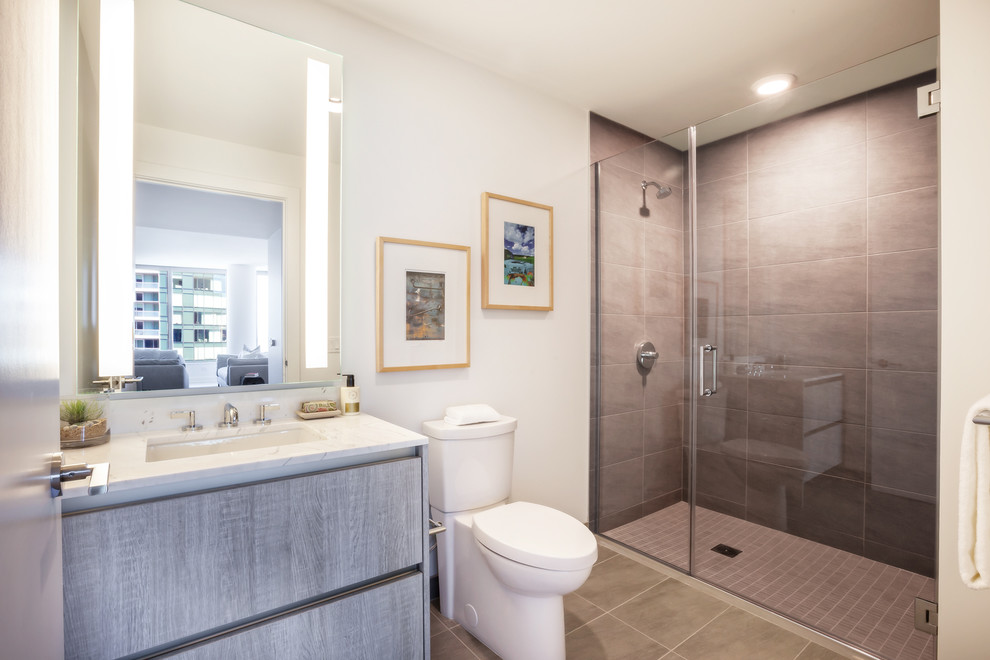 Идея дизайна: ванная комната среднего размера в стиле модернизм с плоскими фасадами, серыми фасадами, ванной в нише, душем в нише, серой плиткой, полом из керамической плитки, душевой кабиной, врезной раковиной и столешницей из кварцита