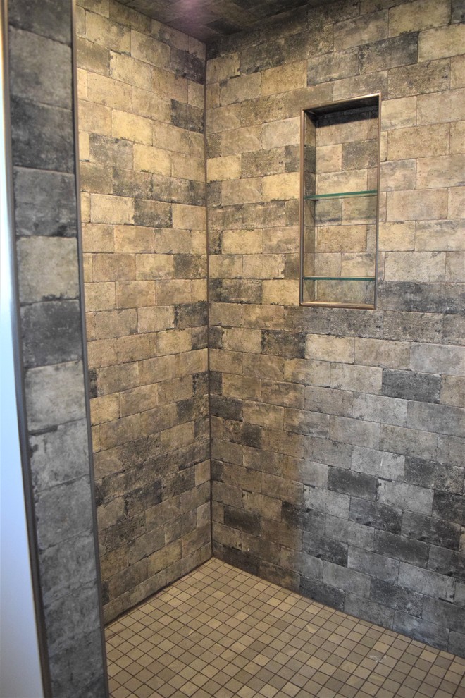 Exemple d'une salle de bain chic avec une douche d'angle, un carrelage gris et un carrelage de pierre.