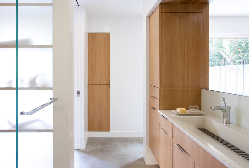 Inspiration pour une salle de bain minimaliste en bois brun avec une grande vasque, un placard à porte plane, un mur blanc et sol en béton ciré.