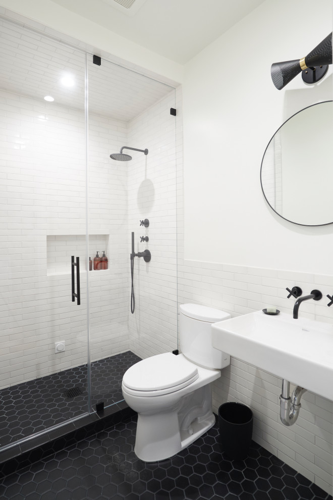 Mid-century modern 3/4 white tile and subway tile ceramic tile and black floor alcove shower photo in San Francisco with a two-piece toilet, white walls, a wall-mount sink, open cabinets, a hinged shower door and white countertops