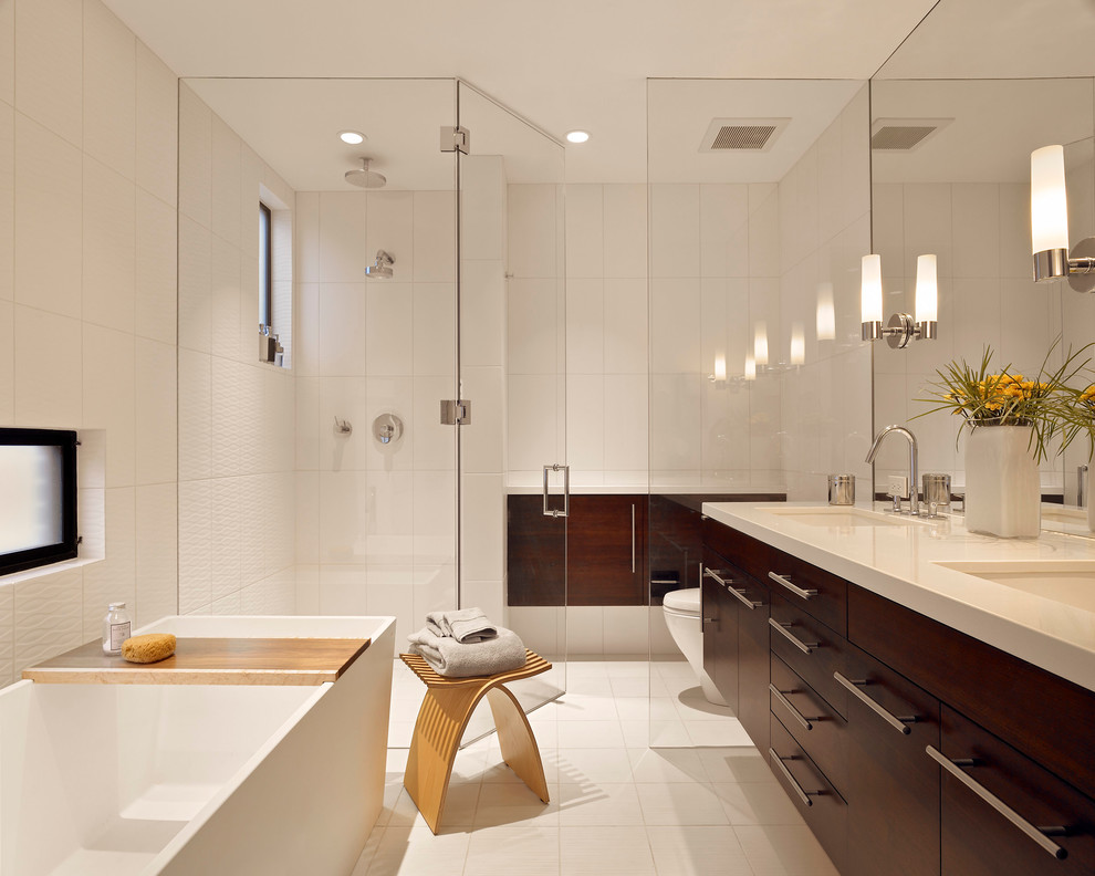 Свежая идея для дизайна: ванная комната в современном стиле с врезной раковиной, плоскими фасадами, темными деревянными фасадами, отдельно стоящей ванной, душем без бортиков, белой плиткой и окном - отличное фото интерьера
