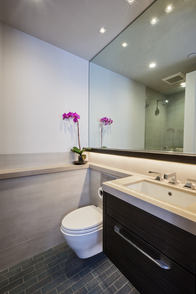 Photo of a medium sized contemporary bathroom in San Francisco with a submerged sink, flat-panel cabinets, dark wood cabinets, quartz worktops, an alcove shower, a wall mounted toilet, blue tiles, stone tiles and terracotta flooring.