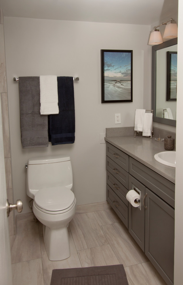 Small contemporary shower room bathroom in Kansas City with shaker cabinets, grey cabinets, an alcove bath, an alcove shower, a two-piece toilet, grey tiles, grey walls, ceramic flooring, a built-in sink and engineered stone worktops.