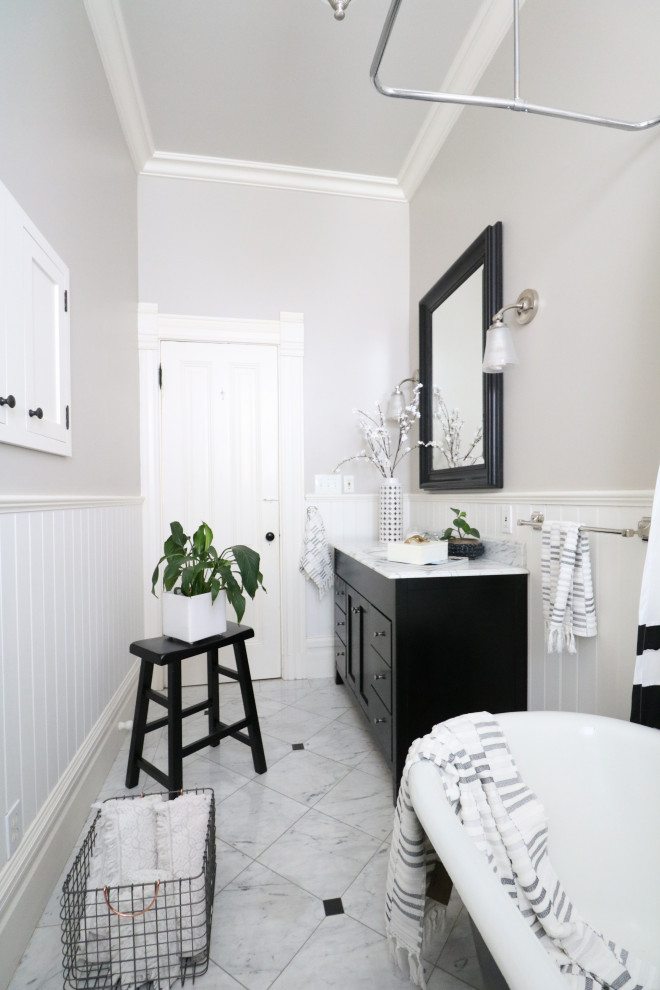 На фото: ванная комната в викторианском стиле с ванной на ножках, мраморным полом, мраморной столешницей, белой столешницей, напольной тумбой и панелями на стенах с