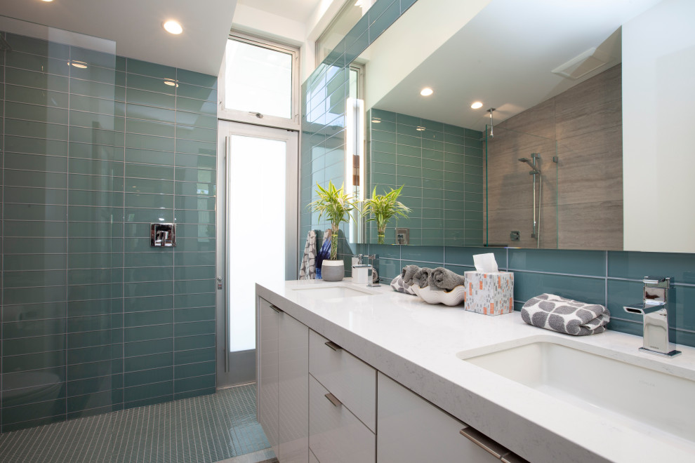 Example of a mid-sized minimalist 3/4 green tile and glass tile porcelain tile and gray floor bathroom design in Other with flat-panel cabinets, white cabinets, white walls, a drop-in sink, quartzite countertops and white countertops