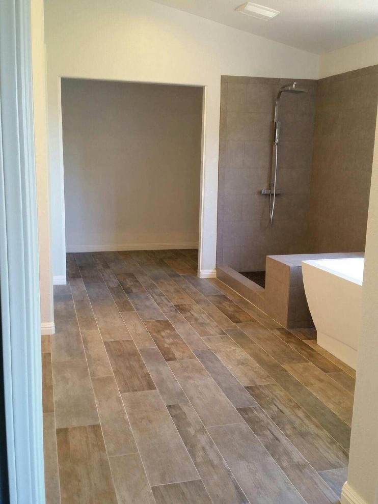 Inspiration for a large southwestern master black tile and ceramic tile light wood floor bathroom remodel in San Francisco with flat-panel cabinets, white cabinets, a one-piece toilet, white walls, an integrated sink and limestone countertops