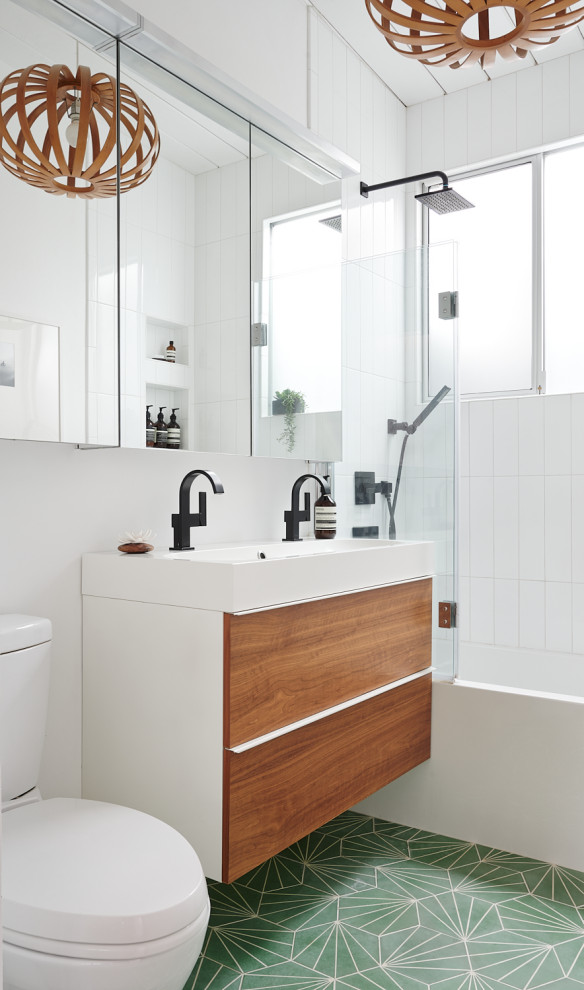 Idéer för att renovera ett 50 tals badrum, med släta luckor, skåp i mellenmörkt trä, ett badkar i en alkov, en dusch/badkar-kombination, vit kakel, vita väggar, ett avlångt handfat och grönt golv