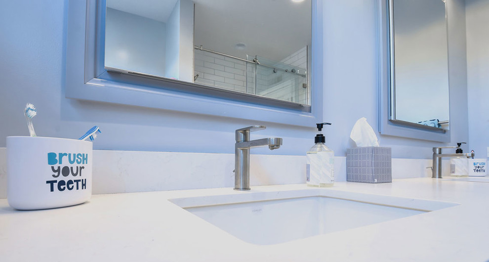 Пример оригинального дизайна: детская ванная комната среднего размера в современном стиле с фасадами в стиле шейкер, синими фасадами, душем над ванной, раздельным унитазом, белой плиткой, плиткой кабанчик, белыми стенами, полом из керамогранита, врезной раковиной, столешницей из искусственного кварца, белым полом, душем с раздвижными дверями и белой столешницей
