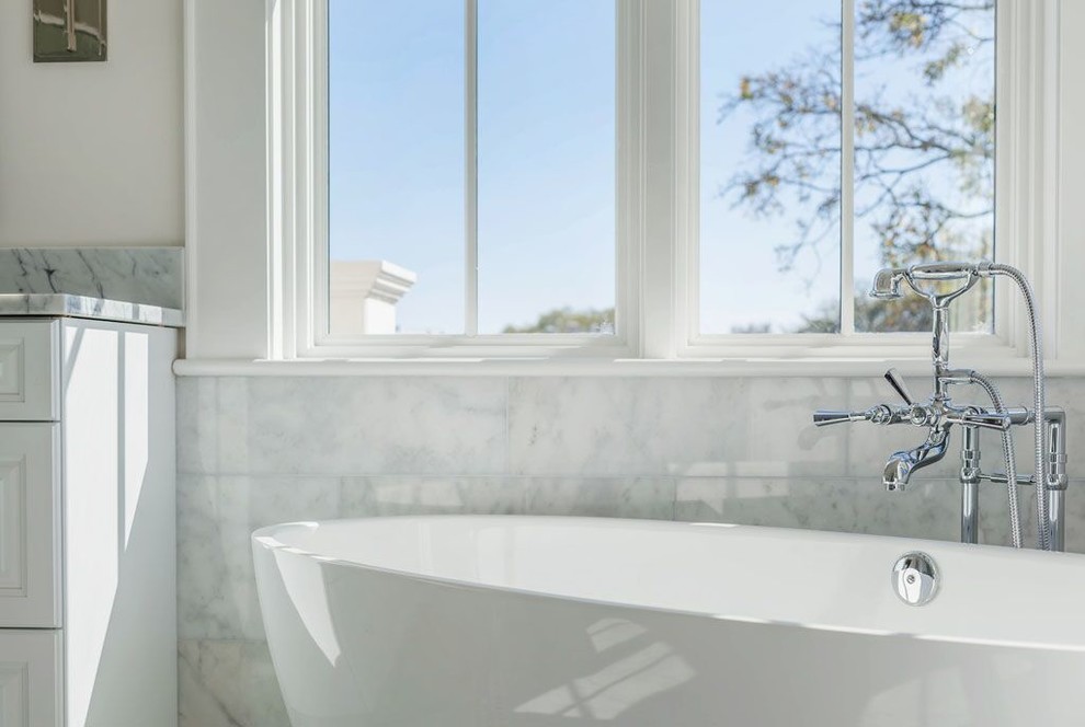 Exempel på ett stort medelhavsstil en-suite badrum, med ett undermonterad handfat, luckor med upphöjd panel, vita skåp, marmorbänkskiva, ett fristående badkar, en bidé, vit kakel, stenkakel, vita väggar och marmorgolv