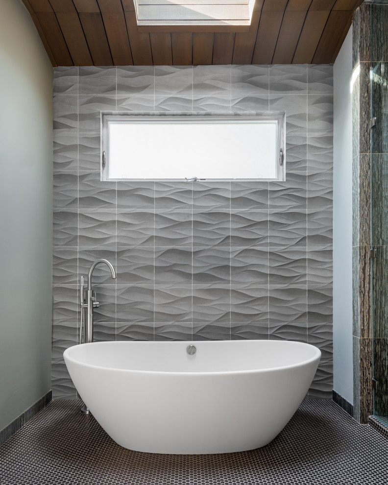 Foto de cuarto de baño actual pequeño con bañera exenta, paredes grises, baldosas y/o azulejos grises y suelo con mosaicos de baldosas