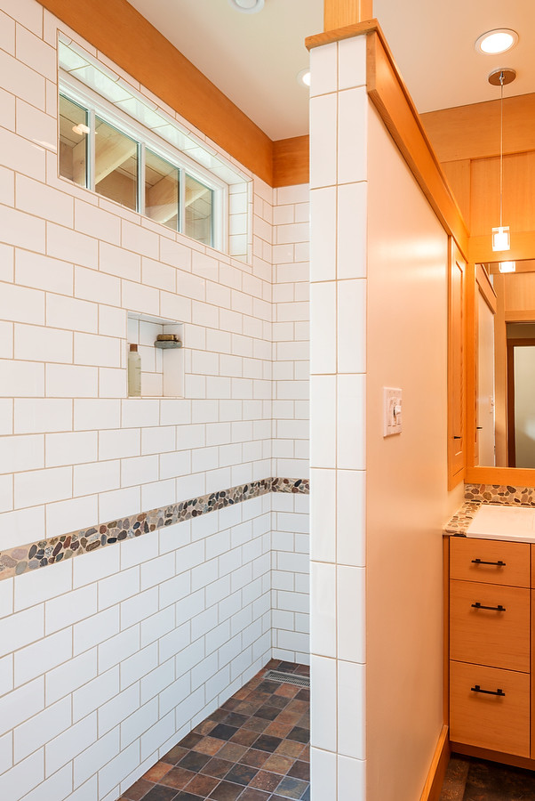 Aménagement d'une salle d'eau classique en bois clair de taille moyenne avec un placard avec porte à panneau encastré, une douche ouverte, WC séparés, un carrelage multicolore, une plaque de galets, un lavabo posé, un mur beige et un sol en ardoise.