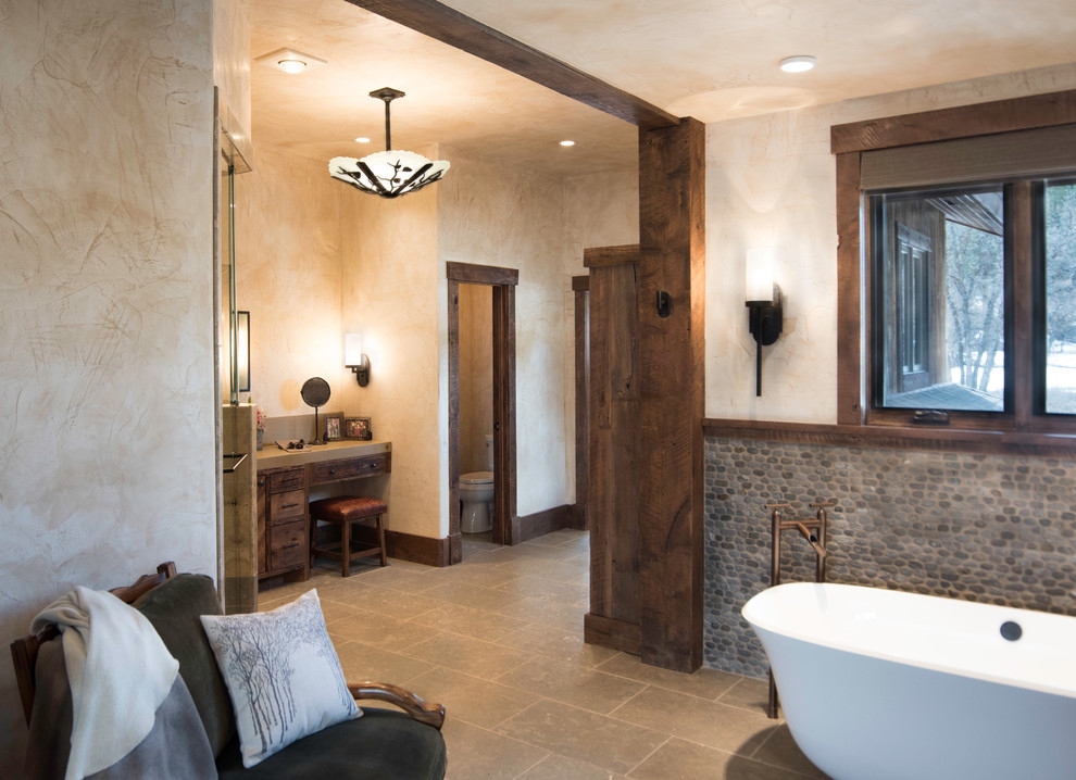 Bathroom - huge rustic master bathroom idea in Albuquerque with flat-panel cabinets, distressed cabinets, a one-piece toilet and beige walls