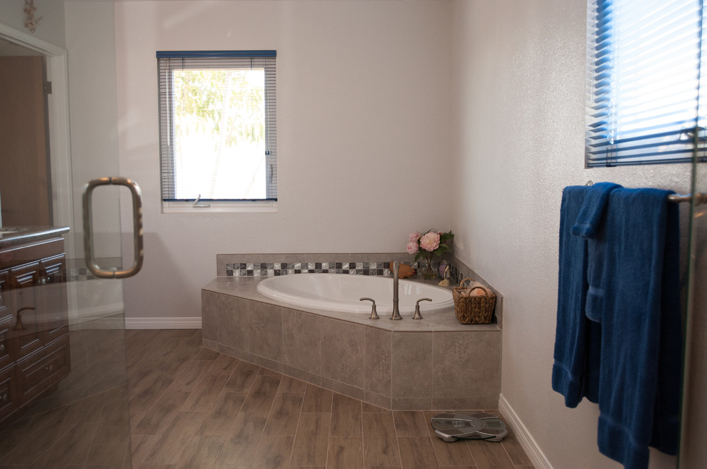 Idées déco pour une douche en alcôve principale classique en bois brun de taille moyenne avec un placard avec porte à panneau encastré, une baignoire d'angle, WC séparés, un carrelage beige, des carreaux de céramique, un mur blanc, un sol en carrelage de céramique, un lavabo posé et un plan de toilette en granite.