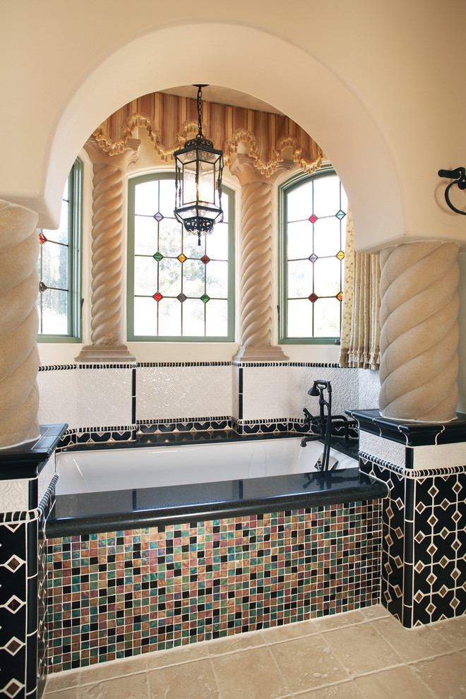 Imagen de cuarto de baño azulejo de dos tonos mediterráneo con bañera encastrada sin remate, baldosas y/o azulejos multicolor y paredes beige