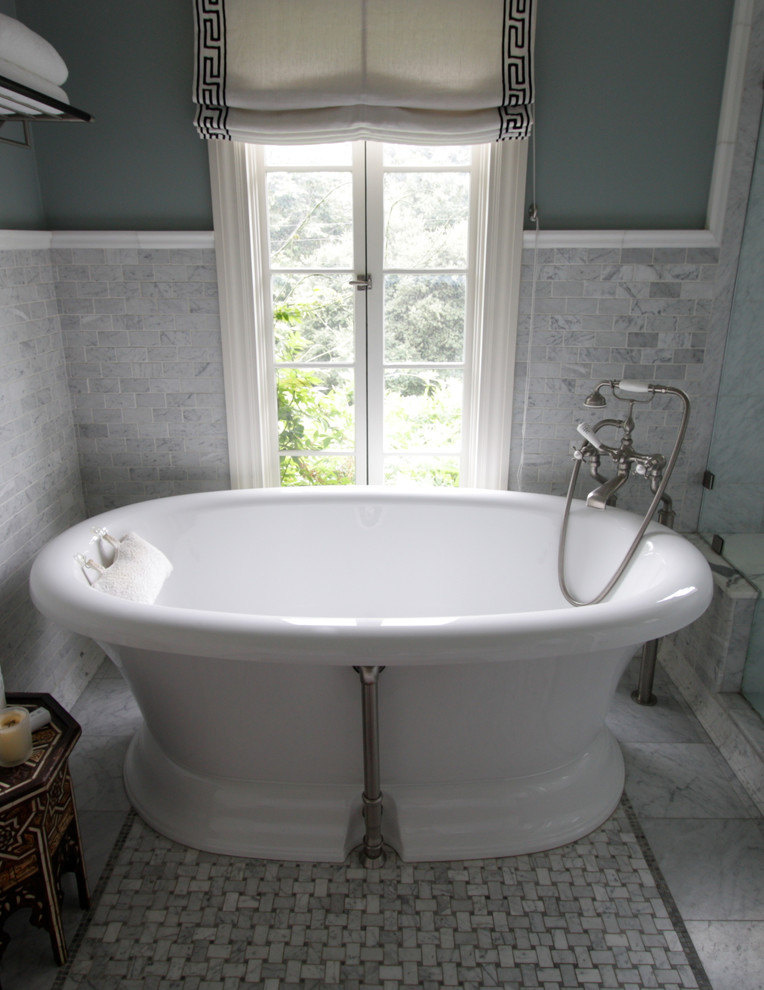 Réalisation d'une grande douche en alcôve principale tradition avec des portes de placard blanches, un plan de toilette en marbre, un carrelage gris, un carrelage de pierre, une baignoire indépendante, un mur vert et un sol en marbre.