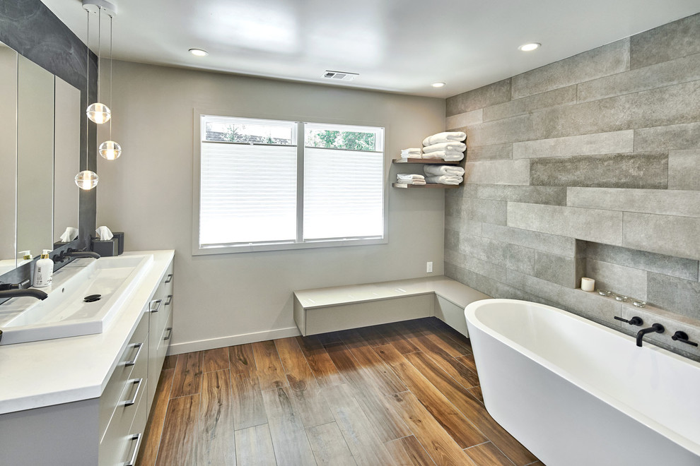 Mid-sized transitional master gray tile and porcelain tile dark wood floor and brown floor bathroom photo in San Francisco with flat-panel cabinets, gray cabinets, white walls, a vessel sink, quartzite countertops, a hinged shower door and white countertops