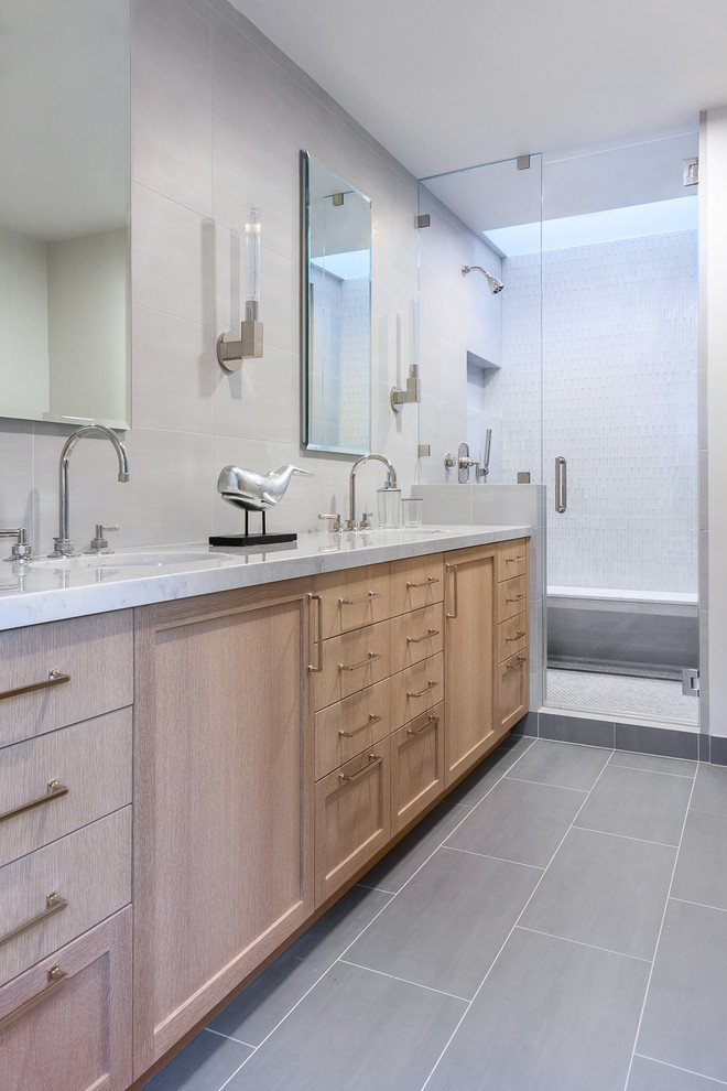 Inspiration for a mid-sized modern master gray tile and ceramic tile ceramic tile corner shower remodel in San Francisco with recessed-panel cabinets, light wood cabinets, a one-piece toilet, gray walls, a drop-in sink and marble countertops