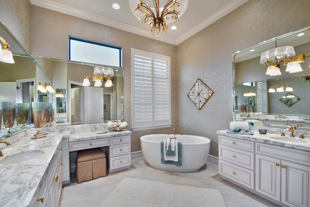 Diseño de cuarto de baño principal clásico con lavabo bajoencimera, puertas de armario blancas, bañera exenta, paredes beige, armarios con paneles con relieve y ventanas