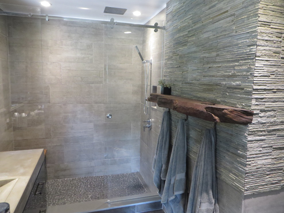Idéer för att renovera ett mellanstort funkis en-suite badrum, med ett integrerad handfat, släta luckor, bänkskiva i betong och en vägghängd toalettstol