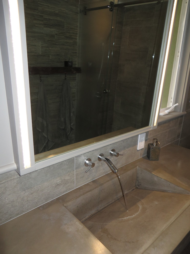 Immagine di una stanza da bagno padronale contemporanea di medie dimensioni con lavabo integrato, ante lisce, top in cemento e WC sospeso