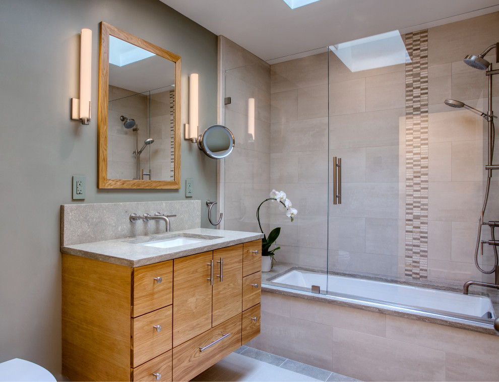 Modern inredning av ett litet grå grått en-suite badrum, med släta luckor, skåp i mellenmörkt trä och bänkskiva i kalksten
