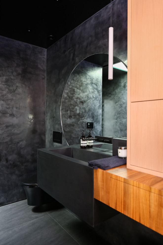 На фото: ванная комната в современном стиле с унитазом-моноблоком, черной столешницей, тумбой под одну раковину и подвесной тумбой