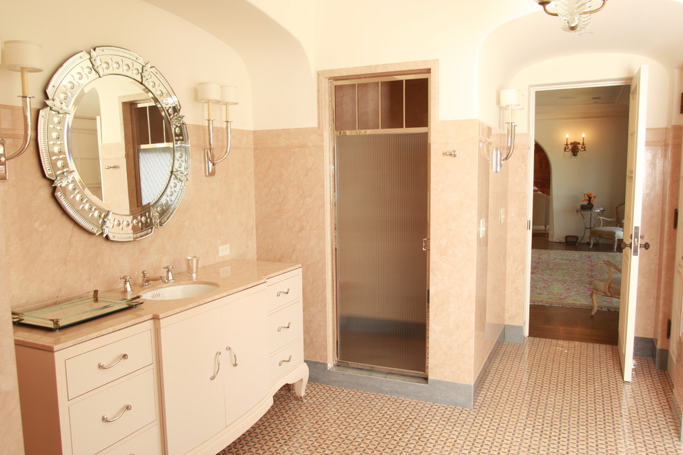 На фото: большая главная ванная комната в классическом стиле с плоскими фасадами, бежевыми фасадами, душем в нише, розовой плиткой, каменной плиткой, розовыми стенами, мраморным полом, врезной раковиной и мраморной столешницей