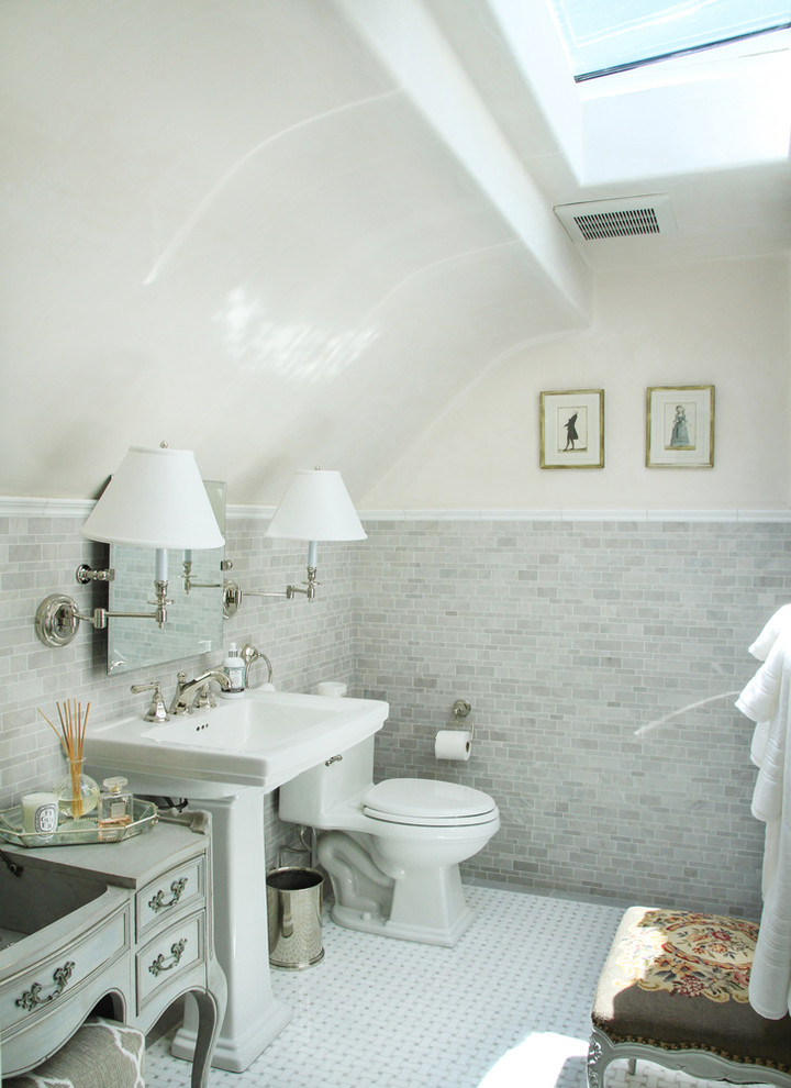 サンタバーバラにあるトラディショナルスタイルのおしゃれな浴室 (ペデスタルシンク、グレーのキャビネット、一体型トイレ	、グレーのタイル、落し込みパネル扉のキャビネット) の写真