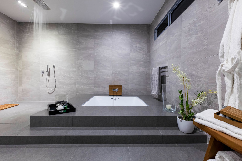 Пример оригинального дизайна: большая главная ванная комната в современном стиле с открытым душем, полом из сланца, полновстраиваемой ванной, серой плиткой и открытым душем