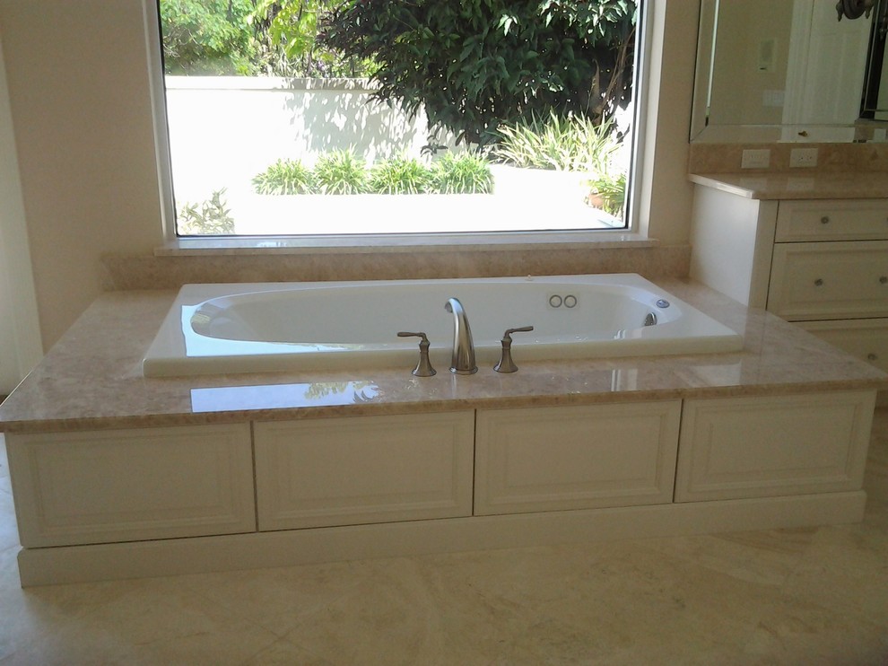 Klassisk inredning av ett stort en-suite badrum, med luckor med upphöjd panel, vita skåp, ett platsbyggt badkar, en hörndusch, beige väggar, klinkergolv i keramik och marmorbänkskiva