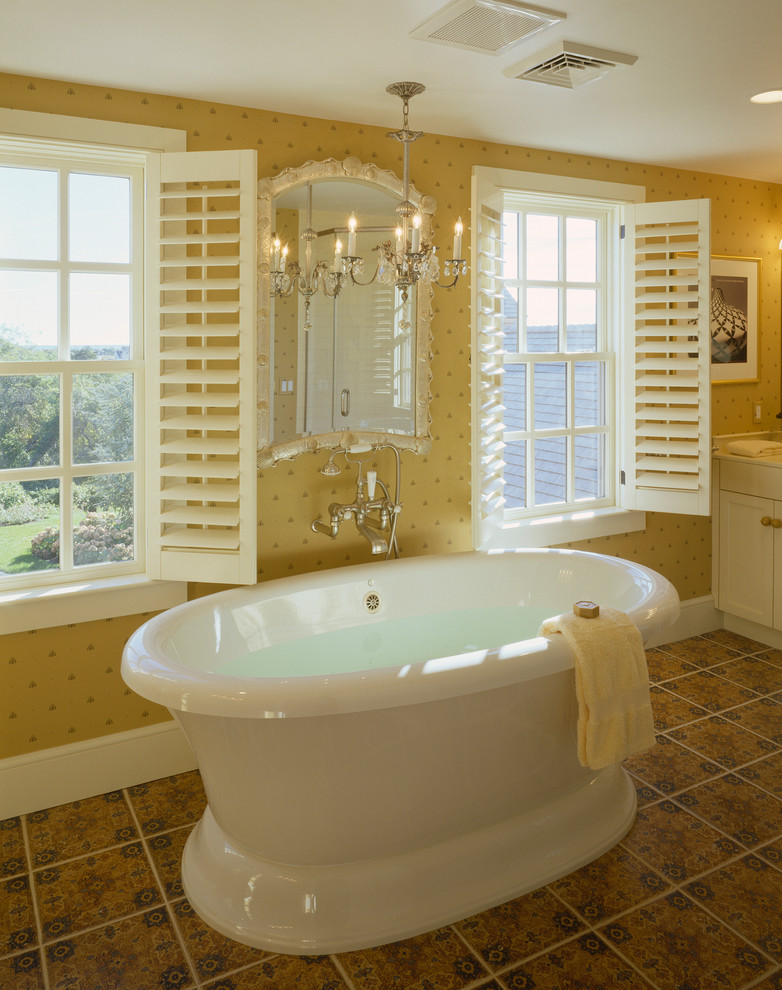 Modelo de cuarto de baño costero con armarios estilo shaker, puertas de armario blancas, bañera exenta, baldosas y/o azulejos multicolor y paredes amarillas
