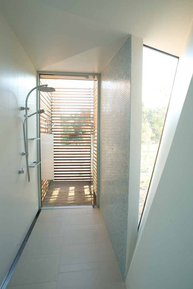 Réalisation d'une salle de bain design avec une douche ouverte, un mur bleu et aucune cabine.