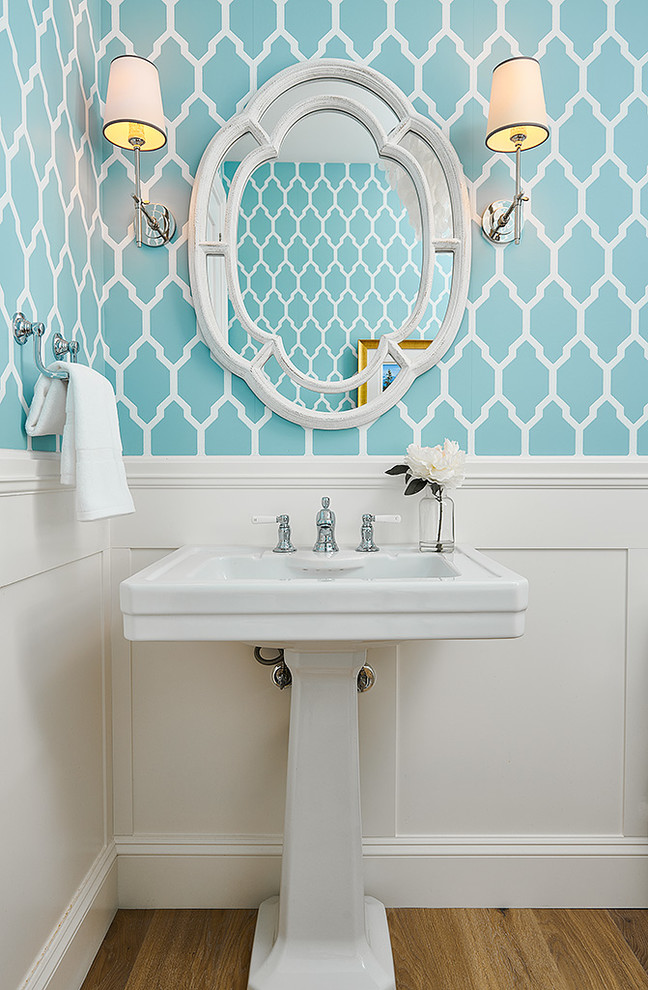 Diseño de cuarto de baño marinero pequeño con paredes azules, suelo marrón, suelo de madera en tonos medios y lavabo con pedestal