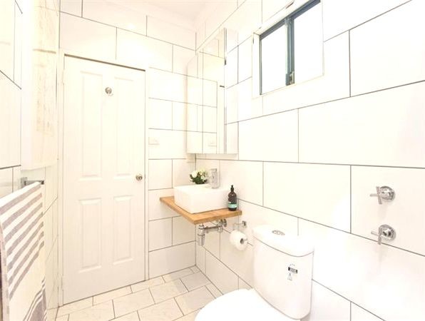 Design ideas for a small contemporary bathroom in Dunedin with a vessel sink, open cabinets, light wood cabinets, wooden worktops, a walk-in shower, a one-piece toilet, white tiles, ceramic tiles, white walls and marble flooring.