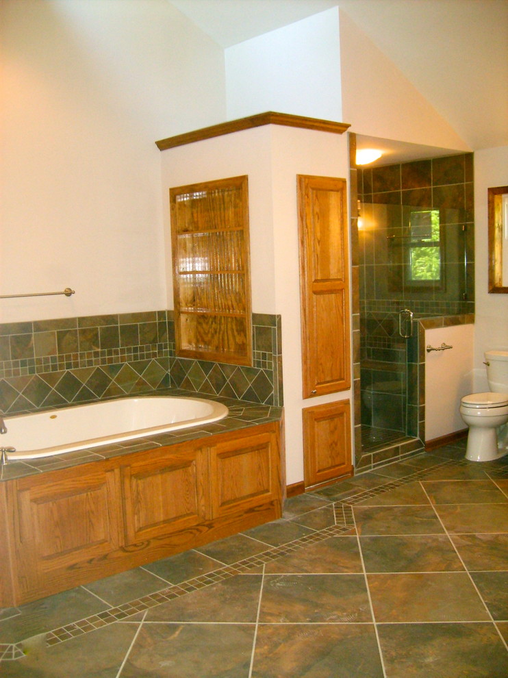 Exempel på ett klassiskt badrum, med ett undermonterad handfat, luckor med upphöjd panel, skåp i mellenmörkt trä, marmorbänkskiva, ett platsbyggt badkar, en dusch i en alkov, en toalettstol med separat cisternkåpa, flerfärgad kakel och porslinskakel