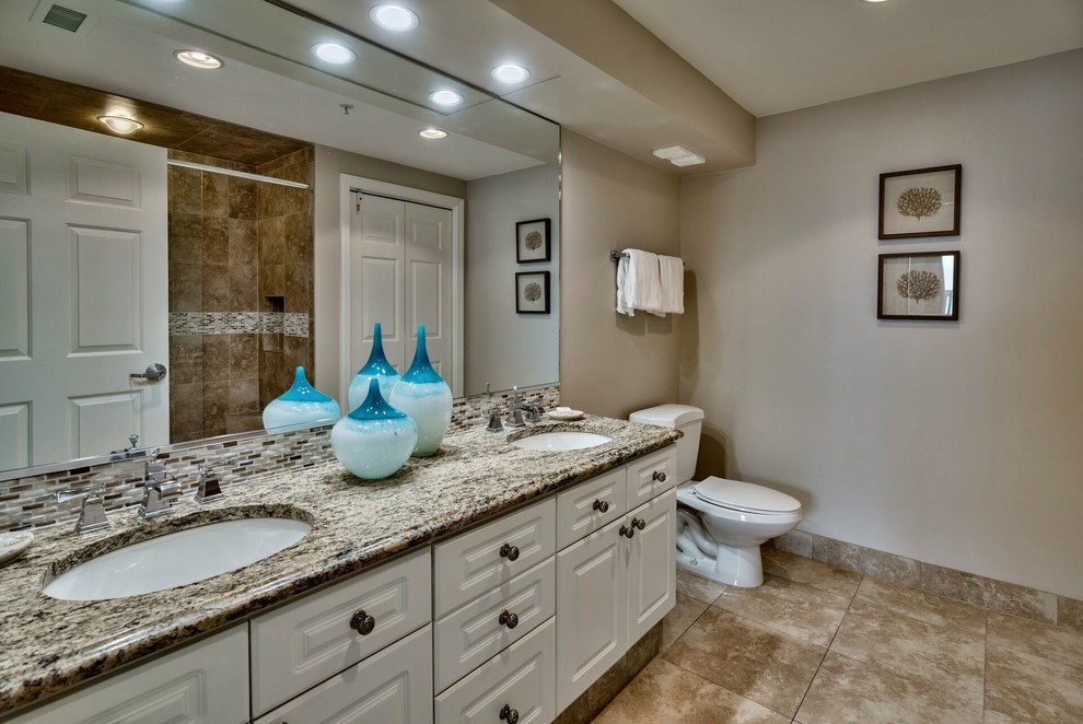 Photo of a medium sized classic ensuite bathroom in Miami with raised-panel cabinets, white cabinets, an alcove shower, beige tiles, ceramic tiles, beige walls, ceramic flooring, a submerged sink, granite worktops, an open shower, a two-piece toilet, brown floors and multi-coloured worktops.