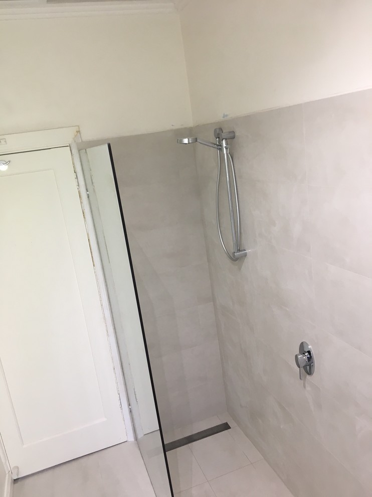 Foto di una piccola stanza da bagno minimalista con bidè, ante lisce, ante bianche, doccia ad angolo, piastrelle bianche, piastrelle in ceramica, lavabo integrato, top in vetro, doccia aperta e top bianco