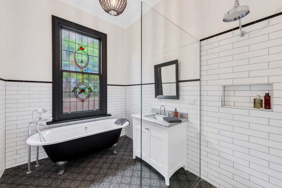 Idée de décoration pour une salle de bain victorienne avec un placard à porte shaker, des portes de placard blanches, une baignoire sur pieds, une douche ouverte, un carrelage blanc, un carrelage métro, un lavabo suspendu, un plan de toilette en marbre et meuble simple vasque.