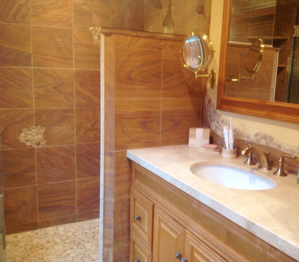 Inredning av ett klassiskt litet en-suite badrum, med en dusch i en alkov, flerfärgad kakel, stenkakel, mosaikgolv, ett undermonterad handfat, luckor med upphöjd panel, skåp i mellenmörkt trä och marmorbänkskiva