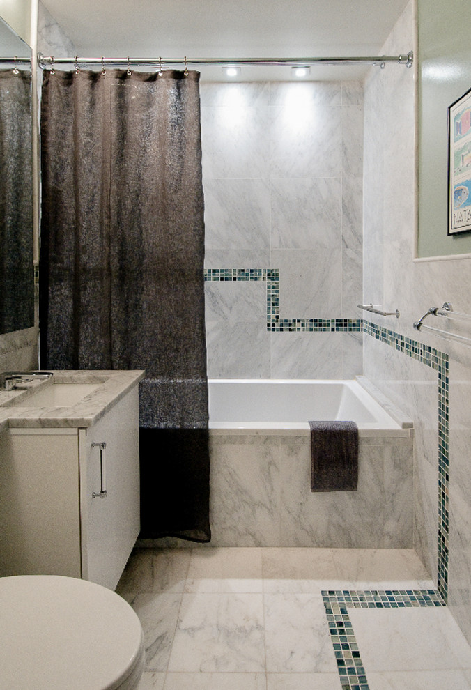 Cette image montre une salle d'eau vintage de taille moyenne avec un placard à porte plane, des portes de placard blanches, une baignoire en alcôve, un combiné douche/baignoire, WC séparés, un carrelage bleu, un carrelage gris, un carrelage multicolore, mosaïque, un mur vert, un sol en marbre, un lavabo encastré, un plan de toilette en marbre, un sol gris, une cabine de douche avec un rideau et un plan de toilette gris.
