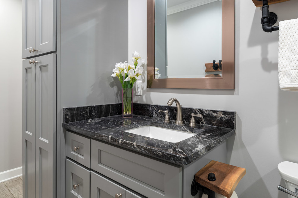 Bathroom - mid-sized transitional master white tile and porcelain tile porcelain tile and gray floor bathroom idea in Other with shaker cabinets, gray cabinets, a two-piece toilet, gray walls, an undermount sink, granite countertops and black countertops