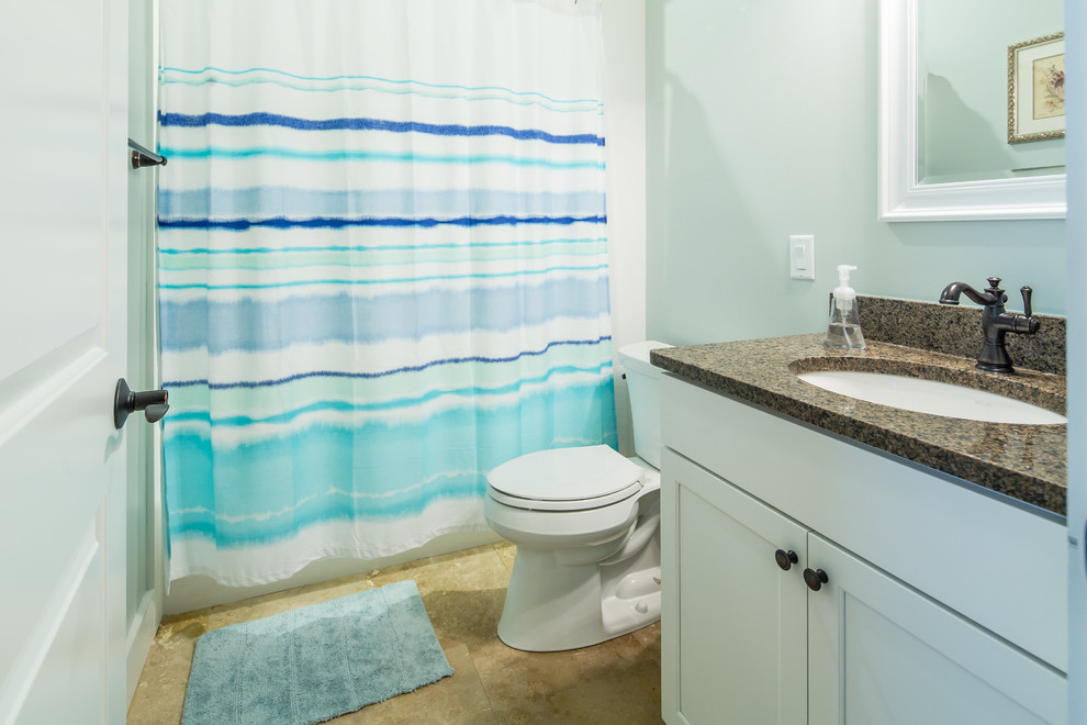 Immagine di una stanza da bagno padronale stile marinaro di medie dimensioni con ante con riquadro incassato, ante bianche, doccia alcova, WC a due pezzi, pareti blu, pavimento in travertino, lavabo sottopiano e top in granito