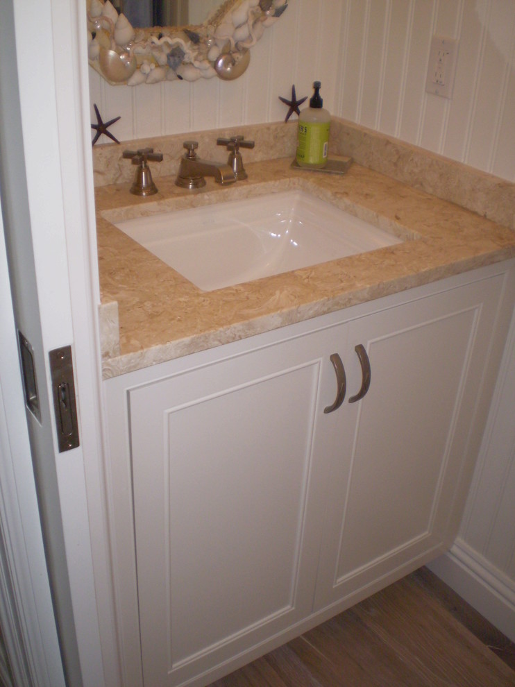 Exempel på ett litet exotiskt badrum med dusch, med ett undermonterad handfat, luckor med profilerade fronter, vita skåp, bänkskiva i kalksten, vita väggar och ljust trägolv